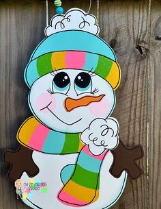 a snowman ornament hanging on a wooden fence