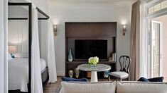 a living room filled with furniture and a flat screen tv sitting on top of a wall