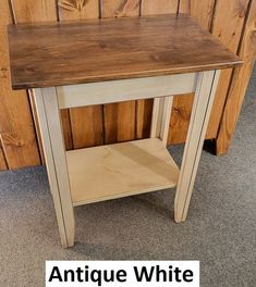 an antique white end table in front of a wood paneled wall with the words antique white on it