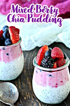 two small jars filled with berries and yogurt on top of a wooden table