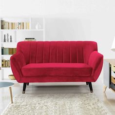 a red couch sitting on top of a white rug