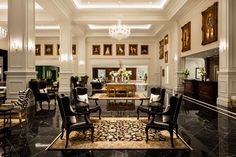 an elegant living room with black and white furniture, chandelier and pictures on the wall