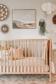 a baby crib in the corner of a room with pictures on the wall above it