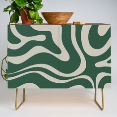 a green and white cabinet sitting next to a potted plant on top of it