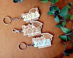 three keychains with graduation decorations on them