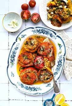 an overhead view of some food on a plate with lemons, tomatoes and bread