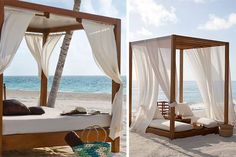 a canopy bed on the beach with white drapes over it's top and bottom