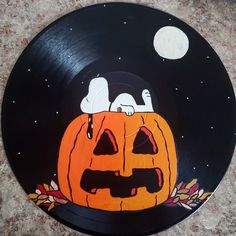 a black and orange plate with a dog on it's head sitting in a jack - o - lantern pumpkin