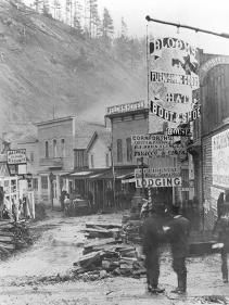 an old black and white photo of people standing in front of a building with many signs on it