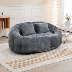 a large grey bean bag chair sitting on top of a rug