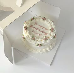 a white cake sitting on top of a box