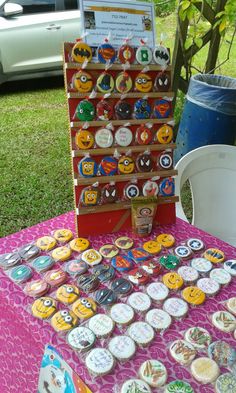 a table topped with lots of cupcakes next to a tree