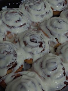 a pan filled with cinnamon rolls covered in icing