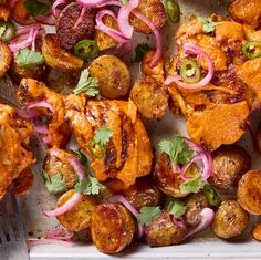 chicken, potatoes and onions on a tray with a fork