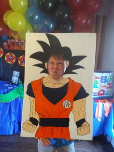 a young boy standing in front of a dragon ball photo