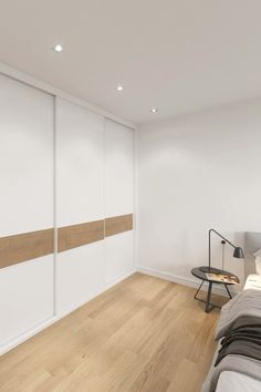 a bedroom with white walls and wooden floors