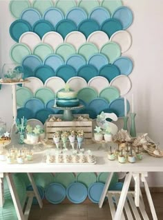 a white table topped with lots of cake and desserts next to a blue balloon