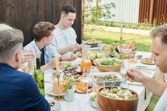 a group of people sitting around a table eating food