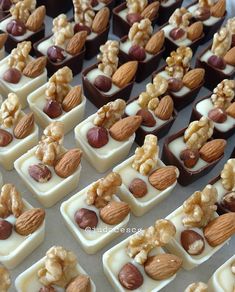 there are many small trays with nuts and chocolate on them that look like candies