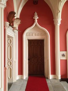 a red carpet is on the floor in front of an ornate doorway with columns and arches