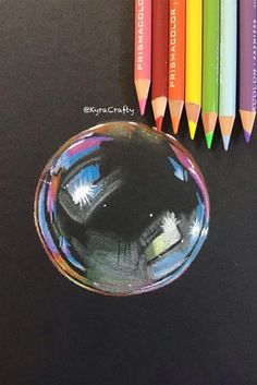 colored pencils are next to a drawing of a person's face in a bubble