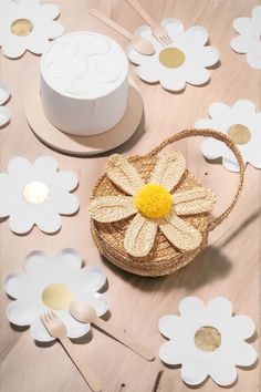 a basket with a flower on it sitting next to some plates and utensils