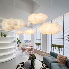 a living room filled with furniture and lots of white clouds hanging from the ceiling above