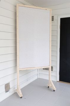 a large white board sitting on top of a floor next to a black front door