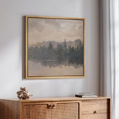 a painting hanging on the wall above a dresser in a room with white walls and wooden furniture