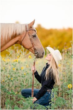 a woman sitting on the ground next to a horse