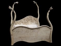 a carved wooden bed with two birds on it