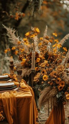 the table is set with yellow cloths and tall vases filled with dried flowers