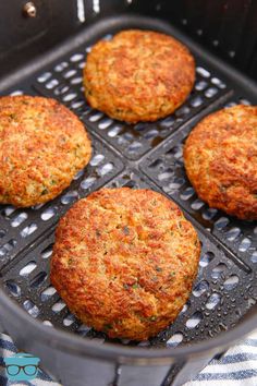 four crab cakes cooking in a frying pan