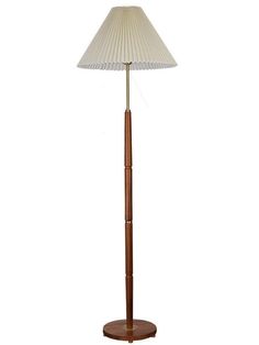 a wooden floor lamp with a white shade