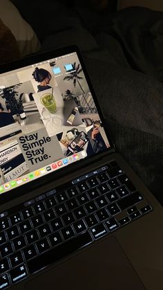 an open laptop computer sitting on top of a bed