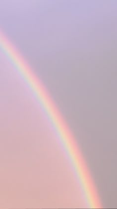 two rainbows are seen in the sky above some trees