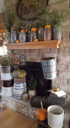 a stone fireplace with pots and pumpkins on it