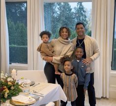 a family poses for a photo in front of a window