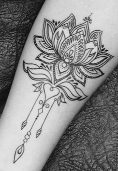 a black and white photo of a woman's arm with a flower tattoo on it