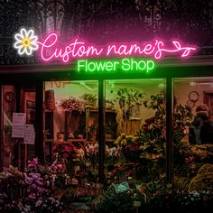 a flower shop with neon lights and flowers in the window