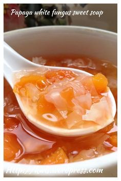 a spoon filled with soup sitting on top of a table