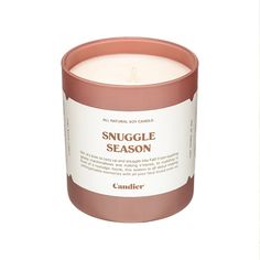 a candle that is sitting on top of a white surface with the words snuggle season in it