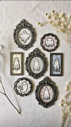 six framed pictures with ghost faces in them on a white wall next to dried flowers