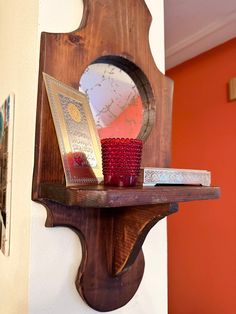 a wooden shelf with a mirror and candle on it