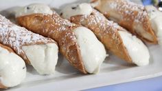 several pastries are arranged on a white platter with powdered sugar toppings