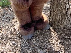 there is a large stuffed bear standing next to a tree