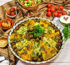 an elaborately decorated food dish on a table with other dishes and utensils