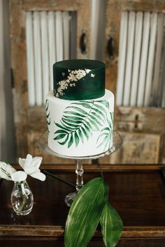 a green and white wedding cake on a table