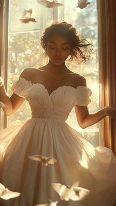 a woman standing in front of a window wearing a white dress with birds flying around her