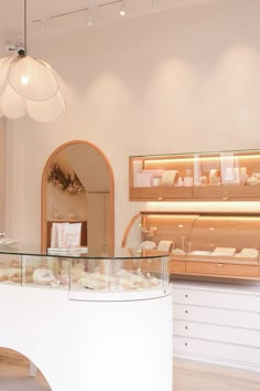 the inside of a bakery with lots of food on display in glass cases and shelves